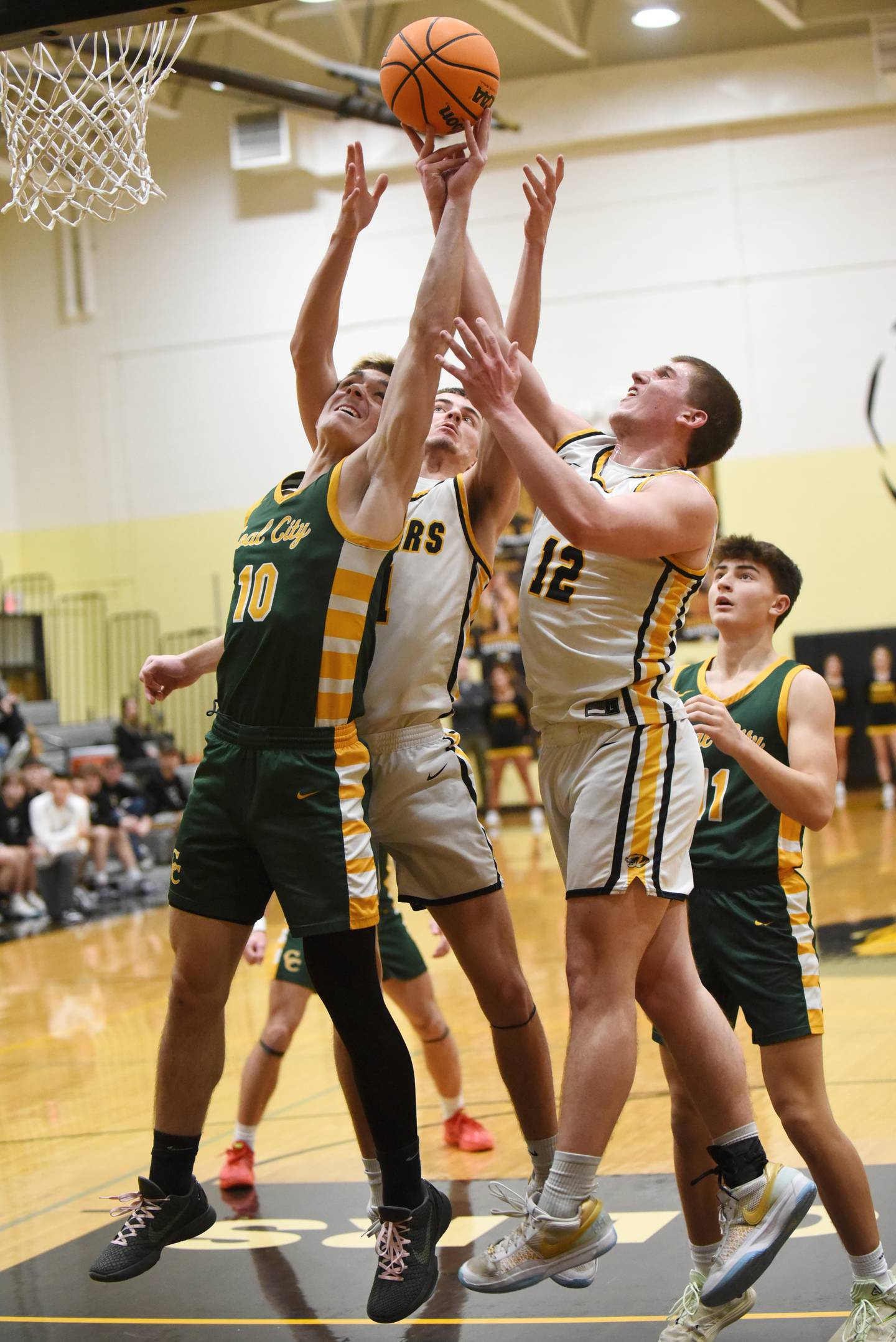 Coal City's Parker Jacovec, left, and Herscher's Tanner Jones, center, and Gavin Hull battle for a rebound during a game at Herscher Tuesday, Jan. 27, 2026.