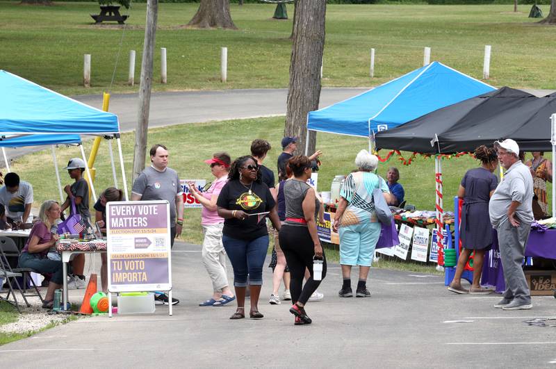 Attendees visit the booths during the Juneteenth Community Celebration Saturday, June 15, 2024, at Hopkins Park in DeKalb.