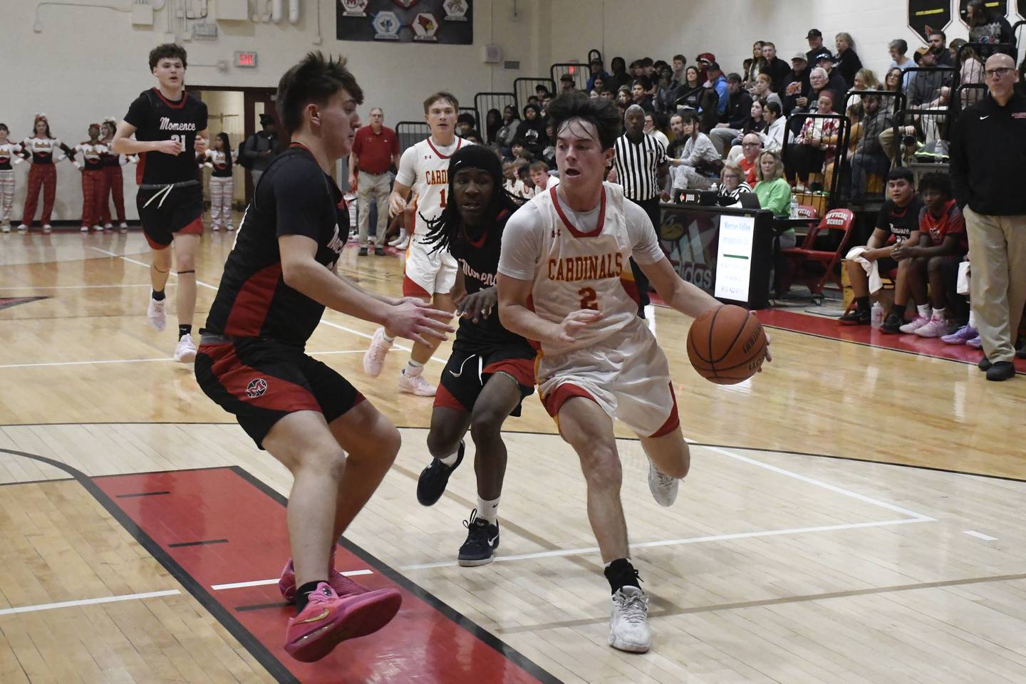 St. Anne's Matthew Langellier drives to the basket while being guarded by Momence's Jackson Ford during St. Anne's 61-46 victory over Momence on Tuesday December 9, 2025.