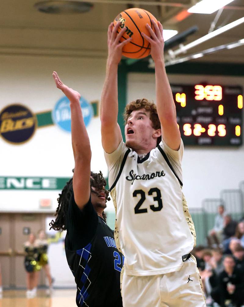 Sycamore's Aidan Mesenbrink goes to the basket against Woodstock's Jeremy Stokes Friday, Feb. 27, 2026, during their IHSA Class 3A boys basketball regional championship game at Boylan Catholic High School in Rockford.