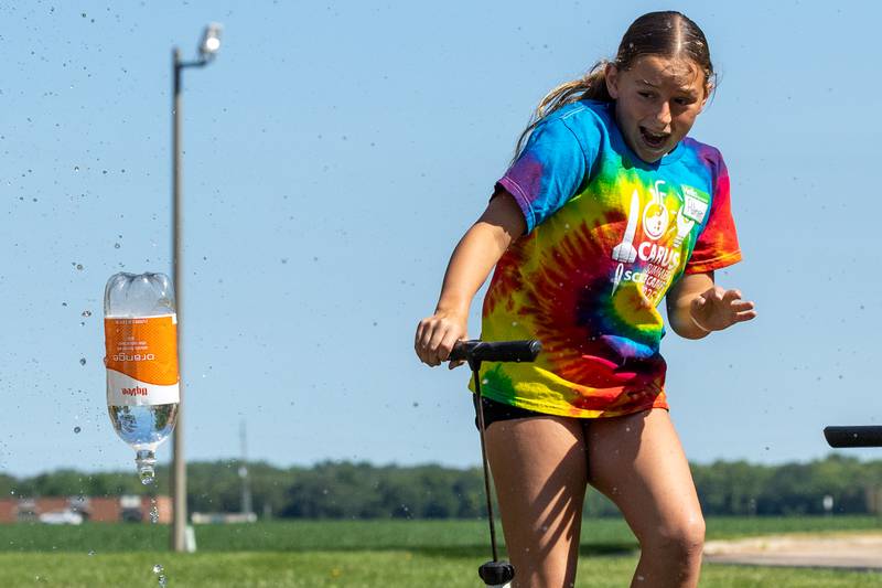 Palmer jumps back as she fires a two liter rocket bottle during the 23rd annual Carus Summer Science Camp on Friday, July 18, 2025 at St. Bede High School in Peru.