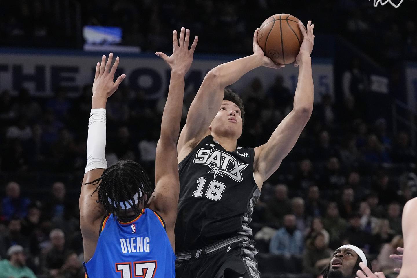 San Antonio Spurs forward Isaiah Roby (18) shoots in front of Oklahoma City Thunder forward Ousmane Dieng, left, during the first half of an NBA basketball game Wednesday, Nov. 30, 2022, in Oklahoma City. (AP Photo/Sue Ogrocki)