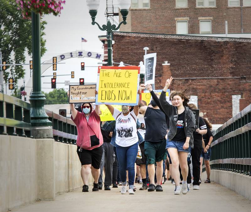 Protesters march across the Galena Avenue Bridge June 13 during a black lives matter protest. The group marched across both bridges in Dixon Saturday evening following speakers at the Dixon riverfront.