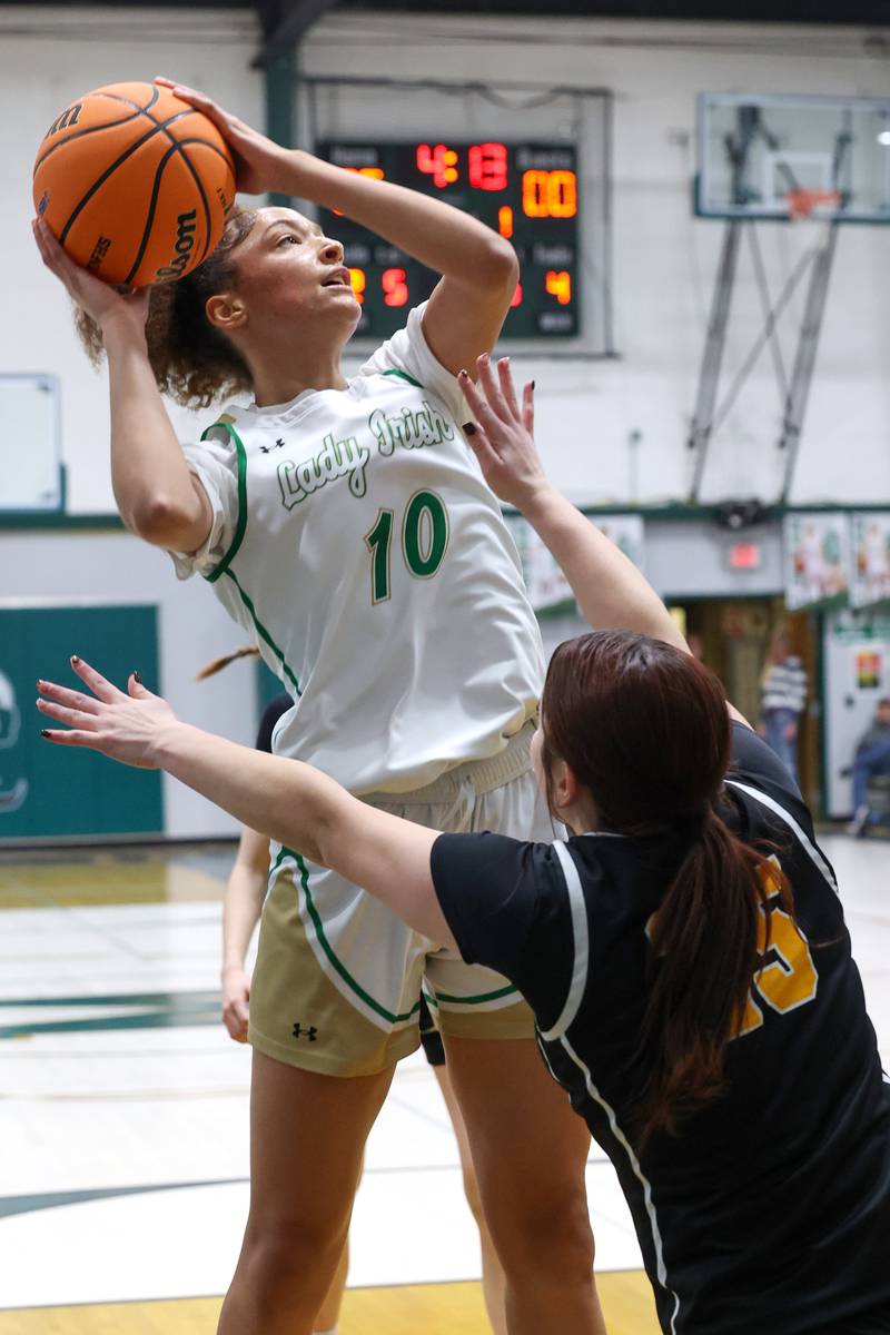 Bishop McNamara's Trinitee Thompson shoots over Reed-Custer's Brooklyn Gonzalez during Bishop McNamara's 60-36 victory over Reed-Custer in the IHSA Class 2A Bishop McNamara Regional semifinals on Monday, Feb. 16, 2026.