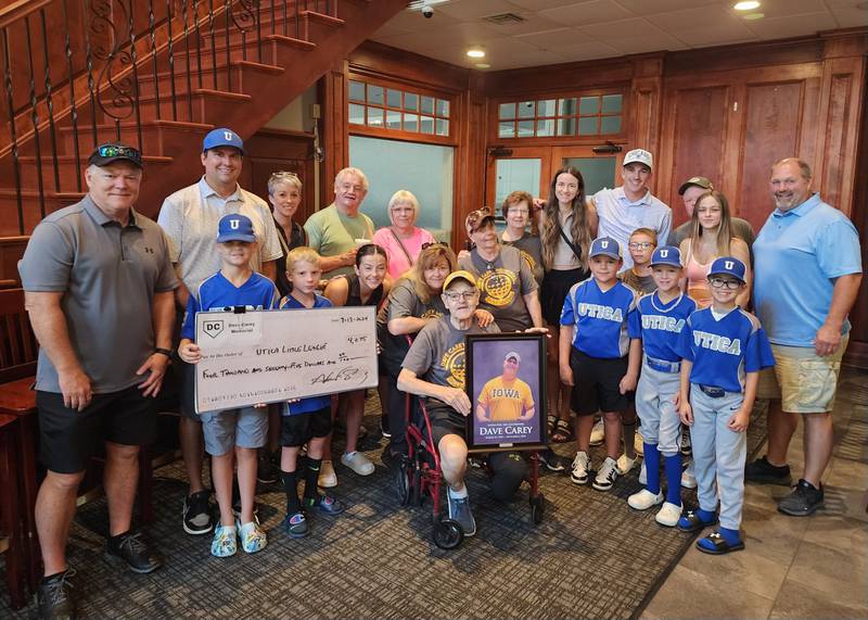 Friends and family of Dave Carey along with players and coaches from the Utica Little League gather for a photo to celebrate the Dave Carey Memorial Fund's continued support of the league.