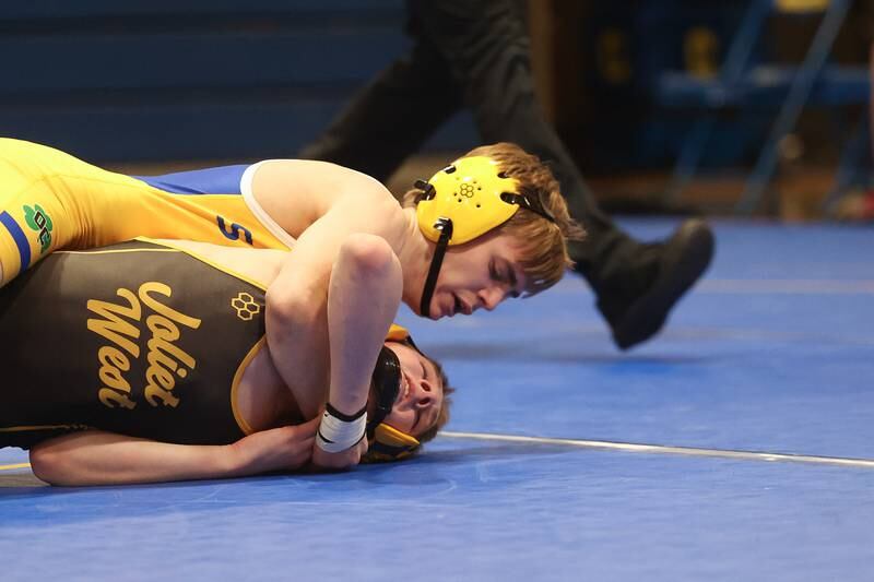 Joliet Central’s Liam Walsh works over Joliet West’s Jakob Crandall in the 113-pound weight match at Joliet Central on Friday, Jan 31, 2025.
