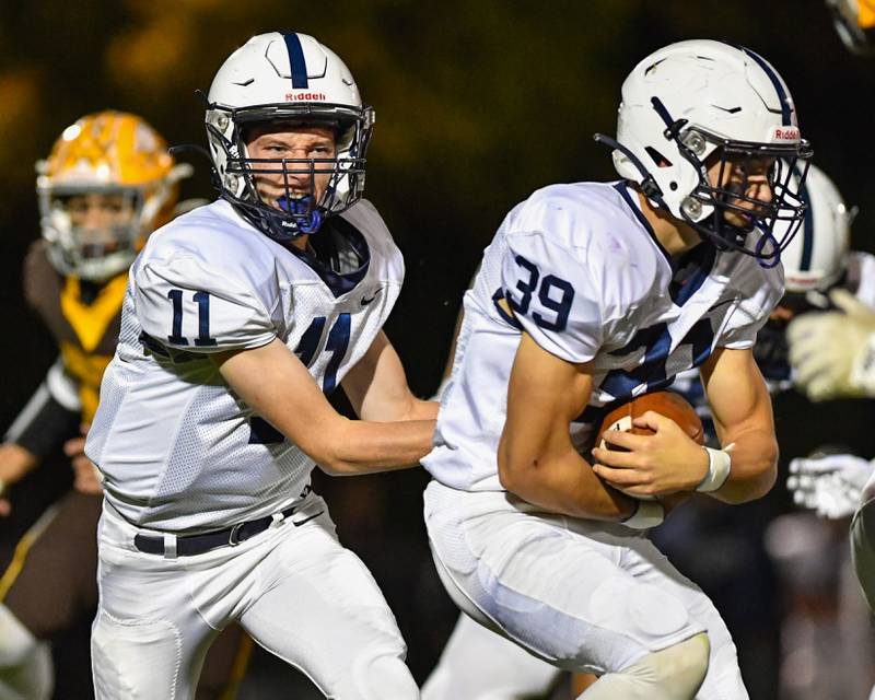 Cary Grove's Peyton Seaburg hands off to Holden Boone  during their Fox Valley Conference game against Jacobs on Friday, Oct. 6, 2022 in Algonquin.