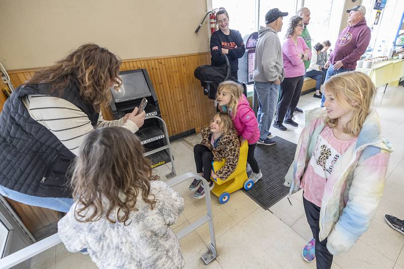 Youngsters play with a kid’s sized shopping cart Saturday, April 4, 2026, during the store closing celebration for family and employees of Oliver’s Corner Market in Dixon.