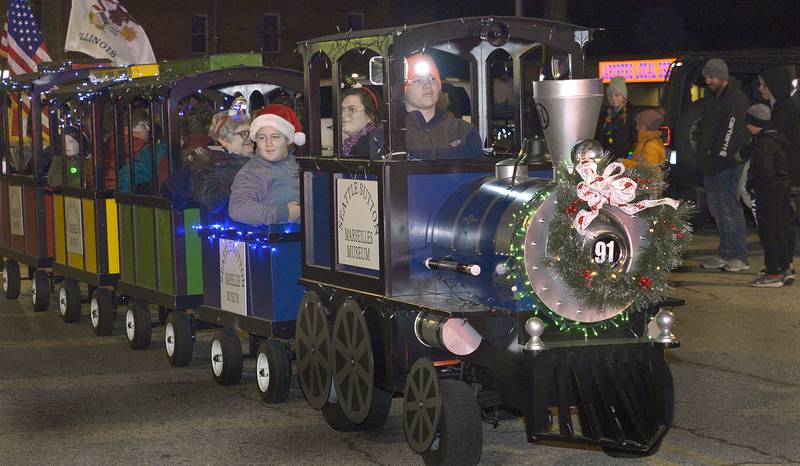 The Seattle Sutton Marseilles Museum train float chugs along Main St Saturday during the annual Holiday Magic Lighted Santa Parade in Marseilles.