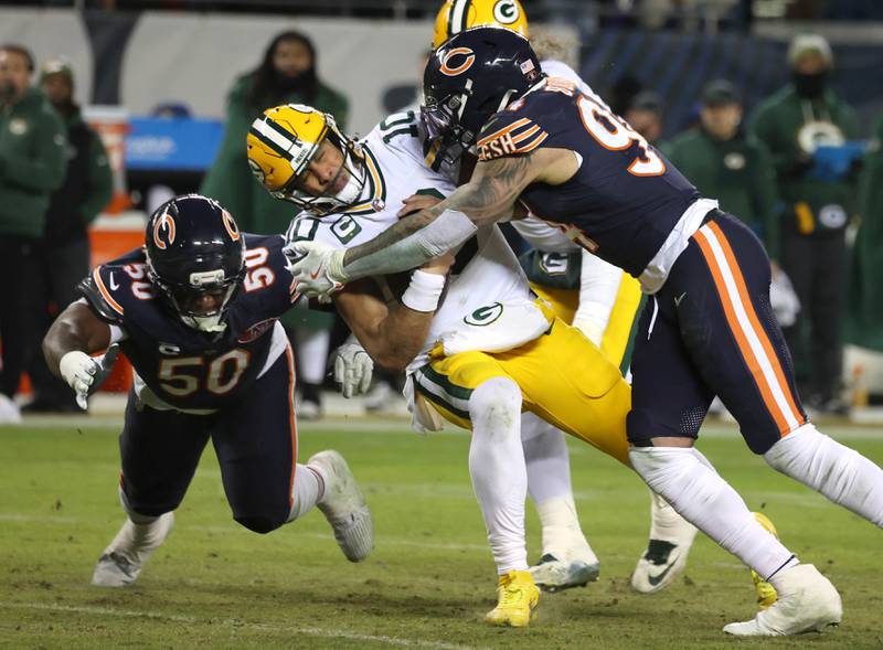 Chicago Bears defensive end Austin Booker (right) and defensive end Grady Jarrett bring down Green Bay Packers quarterback Jordan Love during their NFL Wild Card game Saturday, Jan. 10, 2026, at Soldier Field in Chicago.