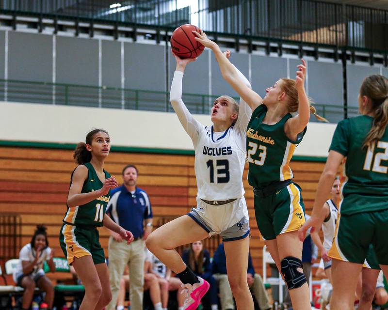 Oswego East's Cassie Van Meter (13) puts up a contested layup at the York Thanksgiving Tournament. Nov 13, 2023.