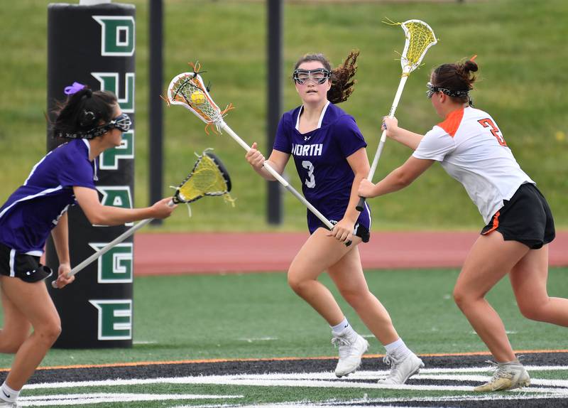 Downers Grove North’s Emma Enright (3) looks to pass to teammate Ella Cho (left) as Crystal Lake’s Lyla Meyers defends during the Benet Supersectional game on June 3, 2025 at College of DuPage in Glen Ellyn.