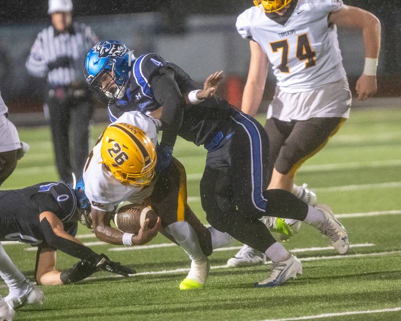 Carmel's Jaquel Edmonds is tackled by St. Charles North's Wyatt Brandt at the Class 7A Second Round playoff game on Saturday, Nov.8,2025 in St. Charles.