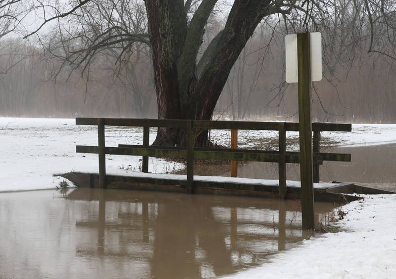 Water rises to the bottom of a pedestrian bridge in the lower parking lot at Starved Rock State Park on Friday, Jan. 26, 2024. The lower parking lot was closed due to the flooding.