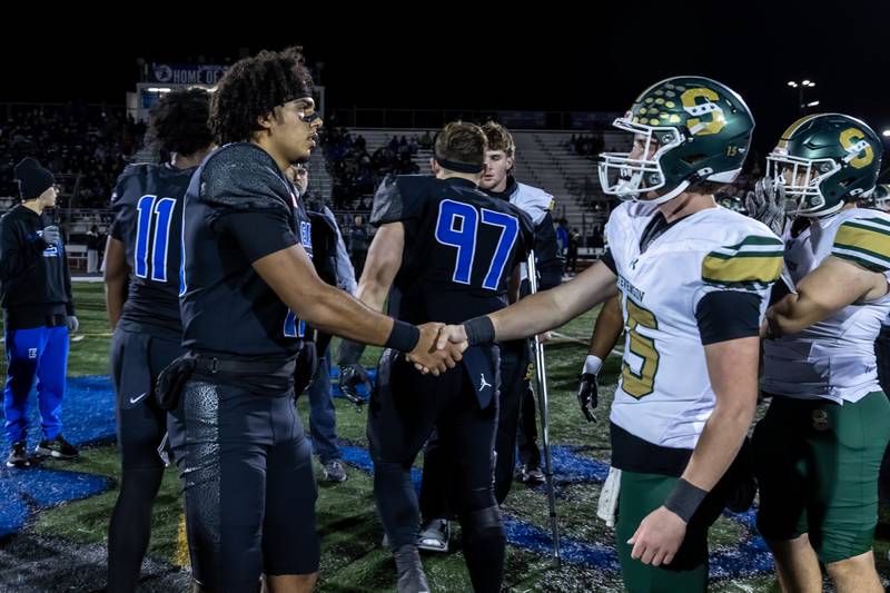Lincoln-Way East's Jonas Williams and Stevenson's Aidan Crawley shake hands prior to a varsity football round one playoff game at Lincoln-Way East on Oct. 31, 2025.