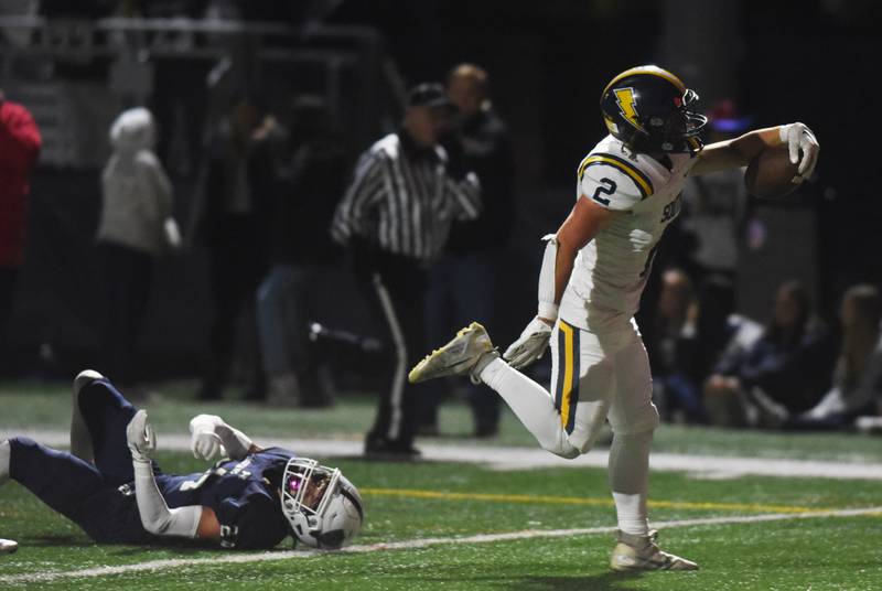 Glenbrook South’s Charlie Gottfred scores a first-quarter touchdown after breaking an attempted tackle by New Trier's Aidan Corboy during Friday’s game in Northfield.