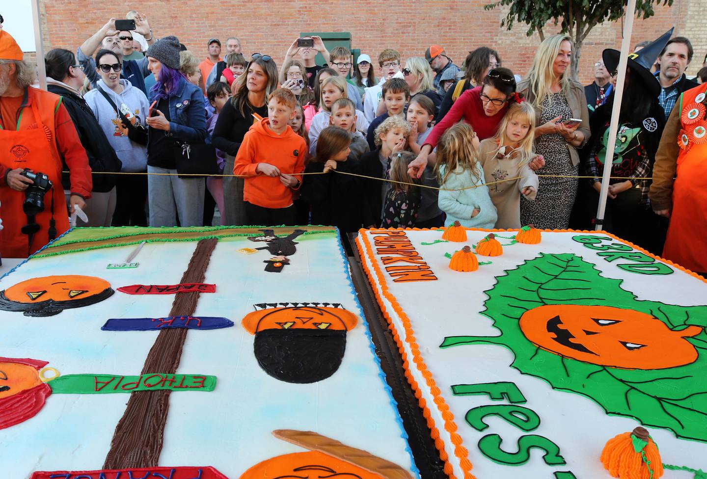 Visitors gather for the cake cutting ceremony Wednesday, Oct. 23, 2024, near the DeKalb County Courthouse during the Sycamore Pumpkin Festival. The cake was donated by the Sycamore Hy-Vee.