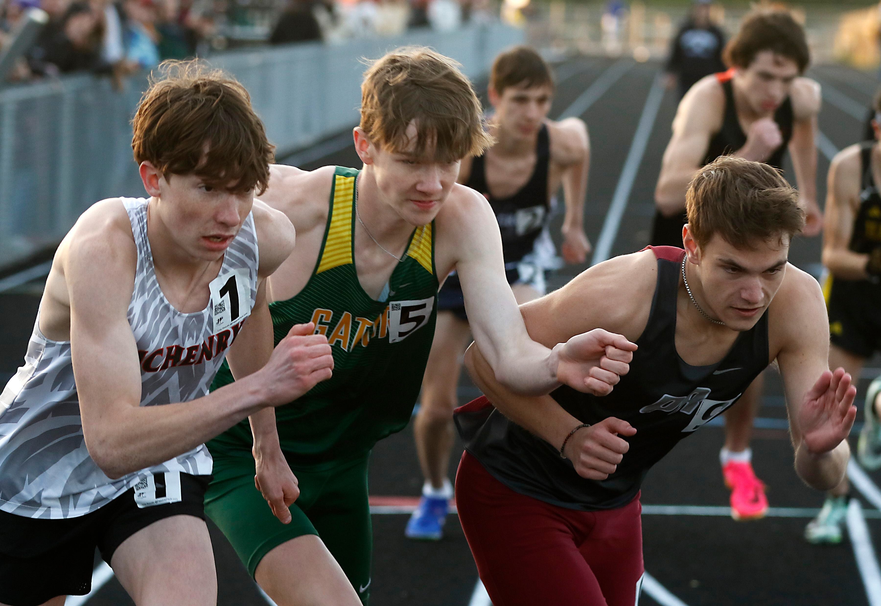 McHenry’s Doug Martin. Crystal Lake South’s Adam Strombom, and Prairie Ridge’s Kevin DeGroot battle for position at the start of the 800 meter run on Friday, April 19, 2024, during the McHenry County Track and Field Meet at Cary-Grove High School.
