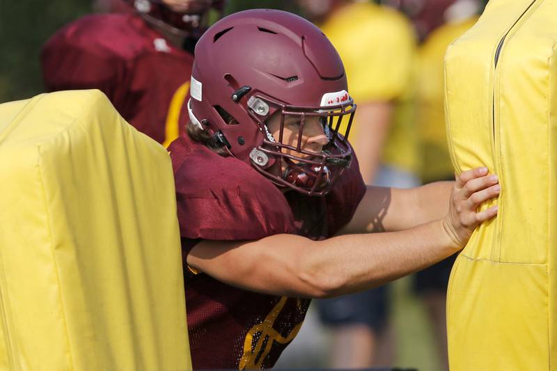 Brock Wood hits the pads during practice with the varsity football team at Richmond-Burton High School on Wednesday, July 14, 2021 in Richmond.