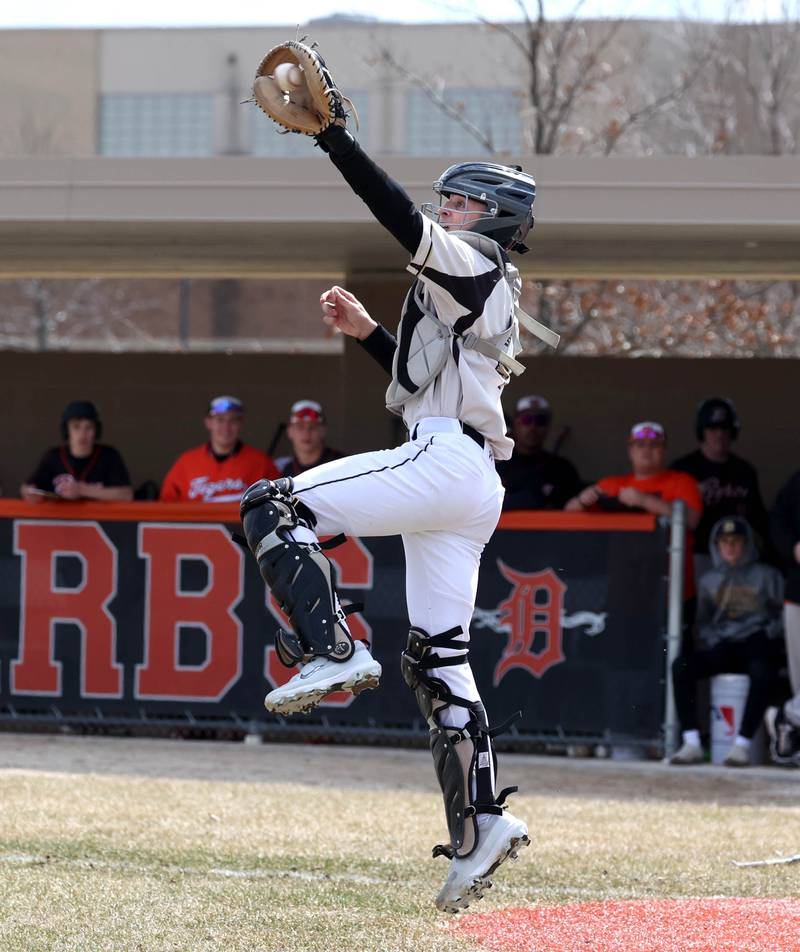 Sycamore's Adam Eder has to go up to get an errant throw home during their game against Byron Wednesday, March 26, 2025, at DeKalb High School. Sycamore’s home field was damaged in last week’s storms so today’s game was played on DeKalb’s field.