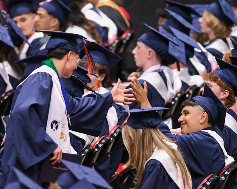 Oswego High School seniors congratulate each other after receiving their diplomas on Saturday May 17, 2025, during the graduation Ceremony held at the Convocation Center in DeKalb.