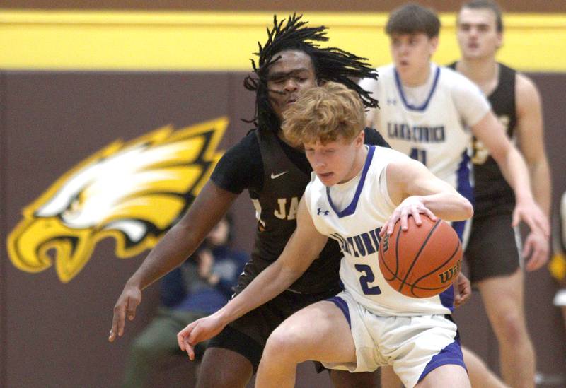 Jacobs’  Emaan Thomas, back, guards Lake Zurich’s Evan Peterson in Hinkle Holiday Classic boys basketball tournament game action at Jacobs High School Tuesday.