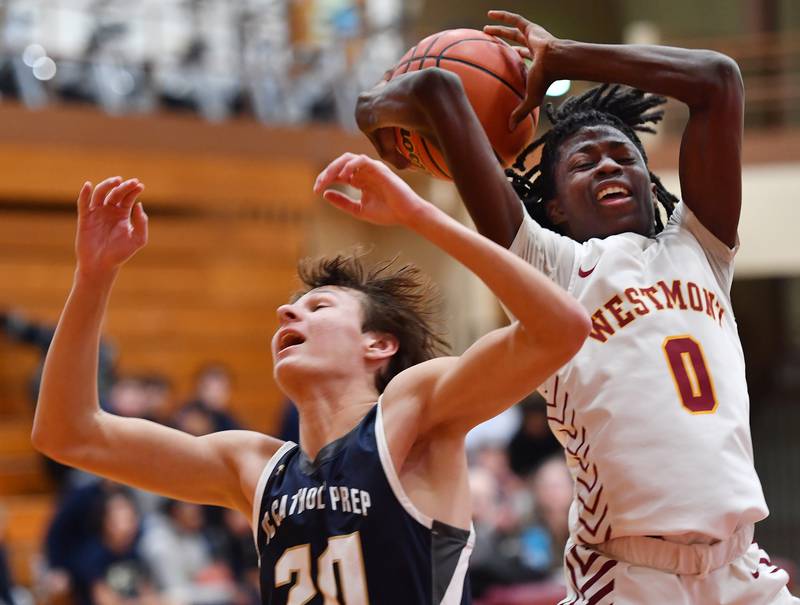 Westmont's Abraham Johnson (0) grabs a rebound over IC Catholic's Danny Fromelt during a game on Jan. 5, 2024 at Westmont High School in Westmont.