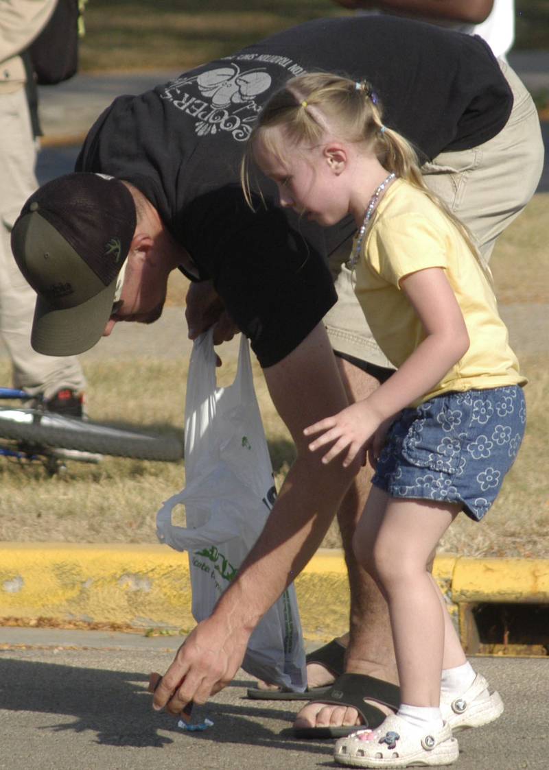 Ryan Raab helps his 4 year old daughter Reagan pick up candy during the parade. The parade took place on Friday afternoon, October 3rd, 2025, prior to the HC football game.
