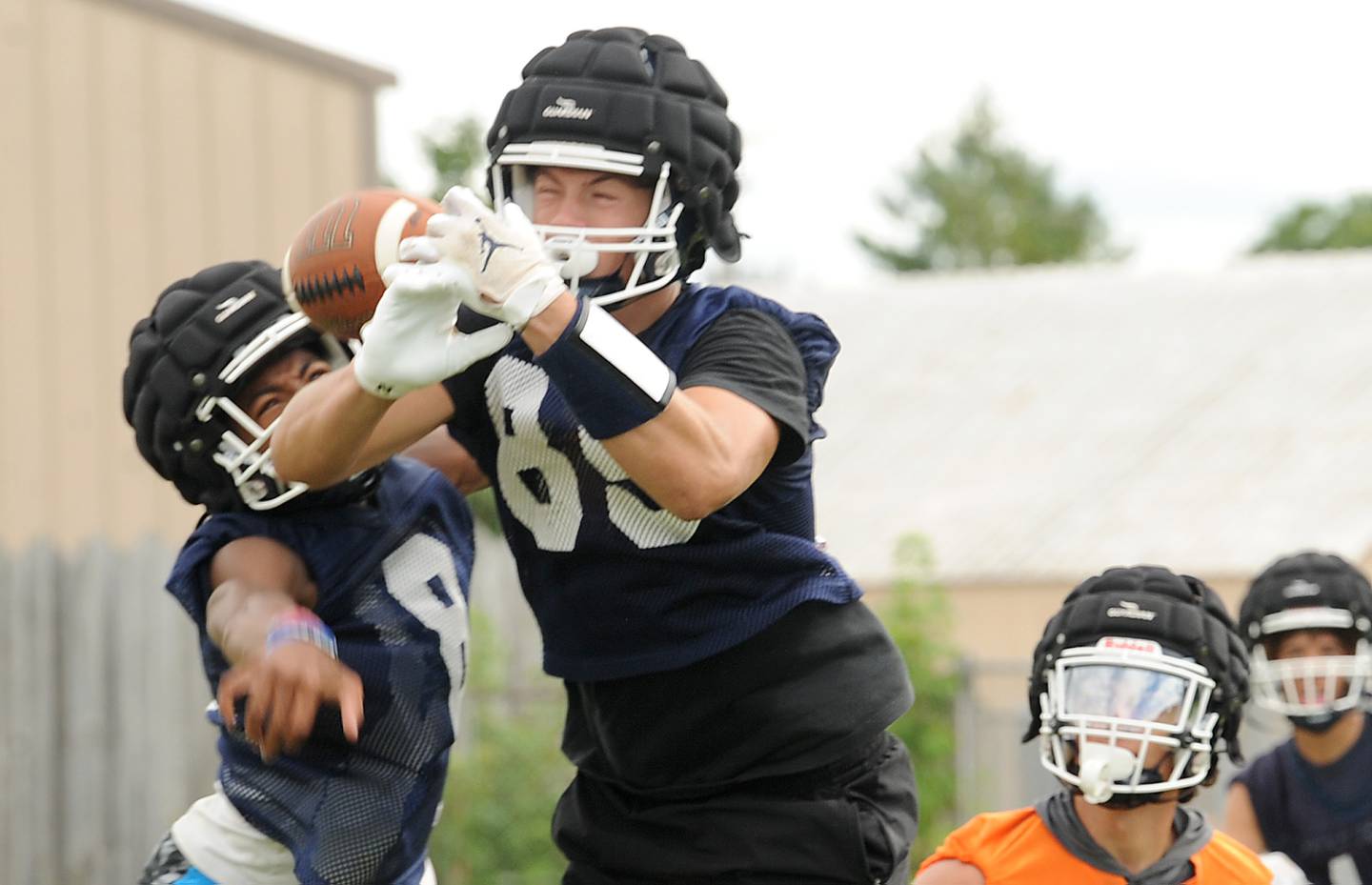 Reciever Deakon Tonielli (89) tries to hold onto a pass under the tight coverage from teammate Jeremiah Cain (8) during a football practice at Oswego High School on Tuesday, August 7, 2022.