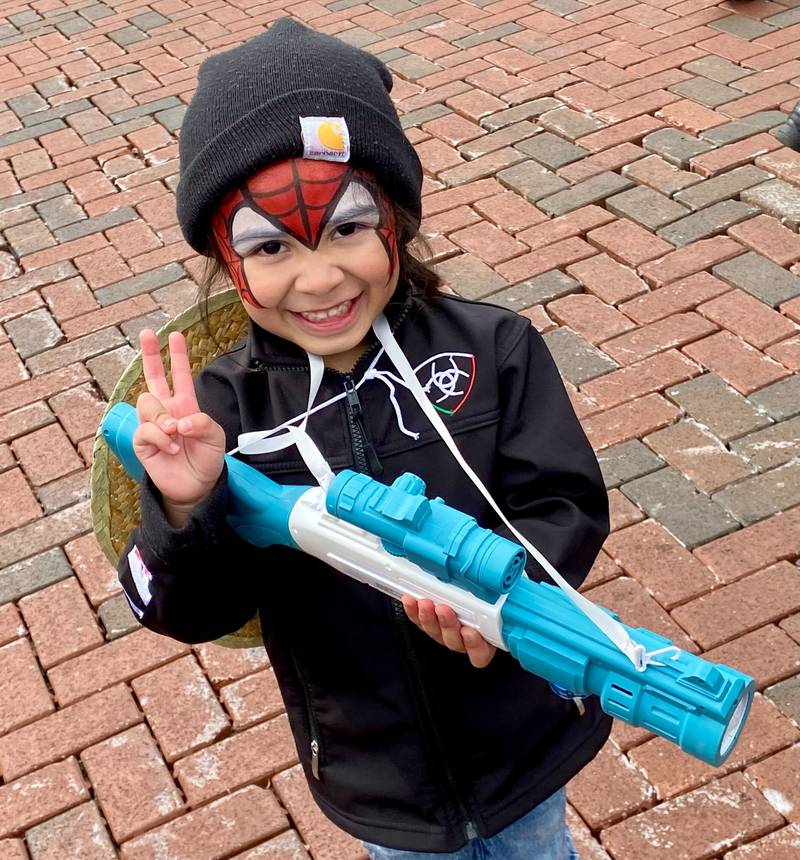 Giovanni Vargas, 4, cheeses for the camera with Spider-Man face paint and a bubble gun toy on Sunday, May 4, 2025, in the Frank Van Buer Plaza in downtown DeKalb for the city's annual Cinco de Mayo Celebration.