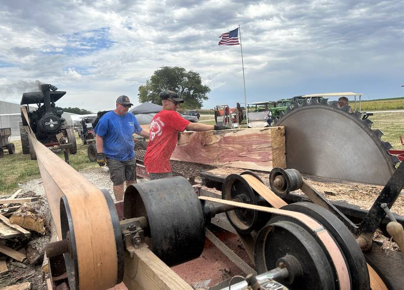 Andy Hinrichs of Oregon (left) and Jack Stange of Emerson were two of the men working on the steam powered sawmill at Bos Bros. Historical Farm's Old Fashioned Fall Harvest south of Erie on Springhill Road Saturday, Sept. 21, 2024. Hands-on demonstrations of past agricultural chores were offered at the event. Here, the sawmill is being used to cut cedar logs into a square so it shingles could be made at another vintage machine. Running the 1916 Case steam engine is Charles Hubbard of Chana.