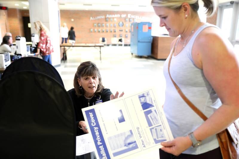 Election Judge Sue Khalaieff (left) assists voter Ainsley Gaddis of Downers Grove in the General Primary Election at Downers Grove North High School on Tuesday, June 28, 2022.