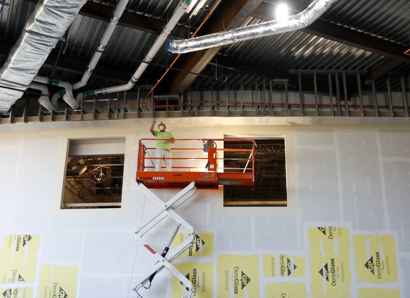 A worker works on the drywall in the lobby of the new Mercyhealth Hospital and Medical Center – Crystal Lake, located at intersection of Three Oaks Road and Route 31, on Friday, Nov. 11, 2022. When complete, the hospital will be home to the city’s first and only 24/7 emergency room as well as private inpatient, surgery and intensive care suites; diagnostic services; and primary and specialty care doctors offices.