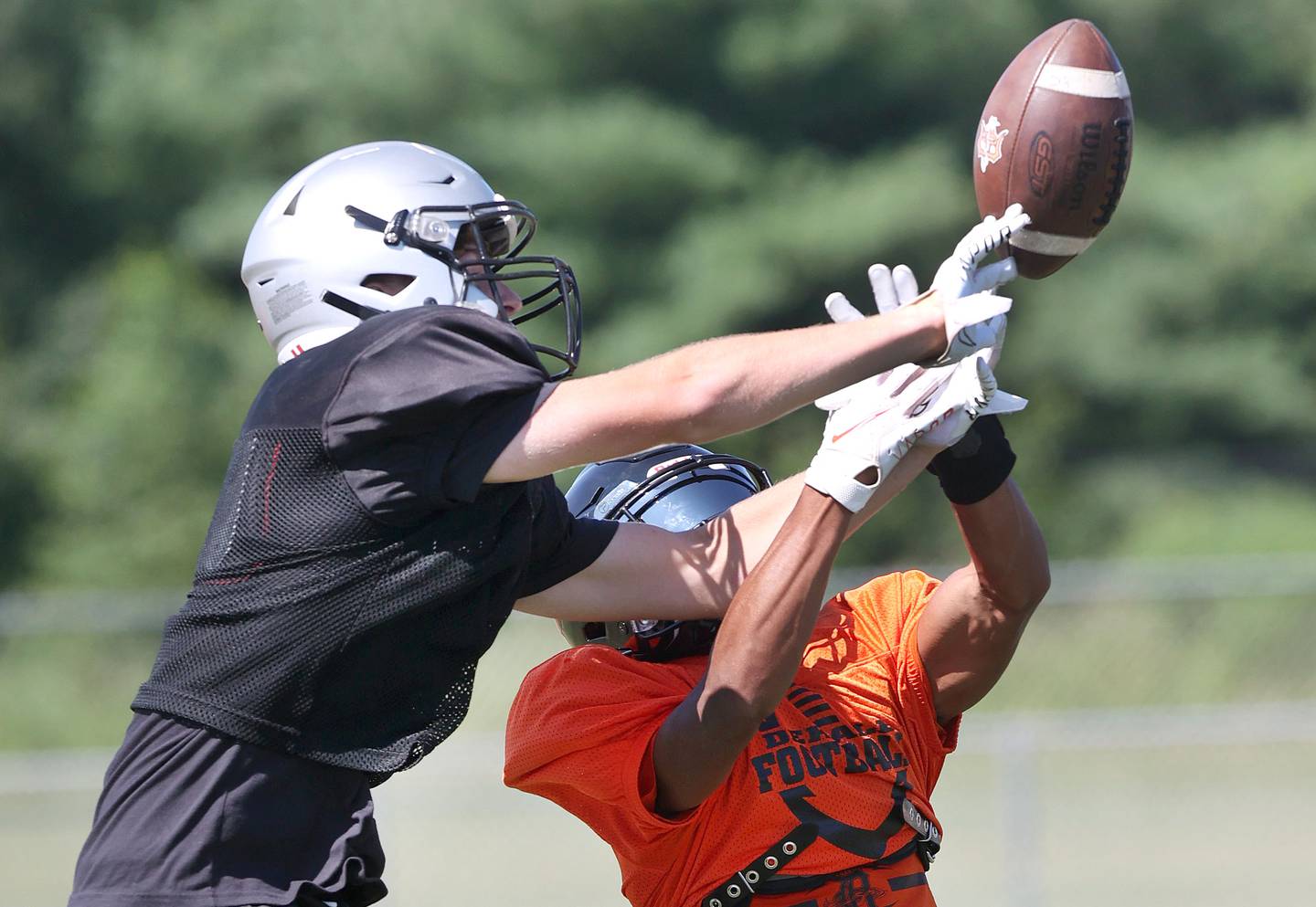 Kaneland's Johnny Spallasso (left) breaks up a pass intended for DeKalb's Xavier Dandridge during a joint practice Thursday, July 14, 2022, at DeKalb High School.