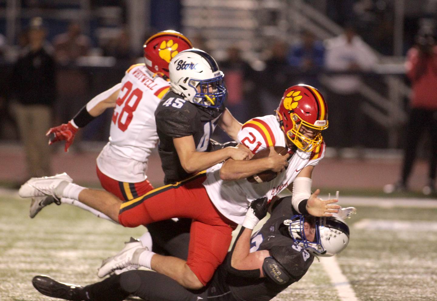 Batavia quarterback Ryan Boe (center) is sacked by St. Charles North’s Jake Furtney (right) and Joseph Vavra during a game at St. Charles North on Friday, Sept. 15, 2023.