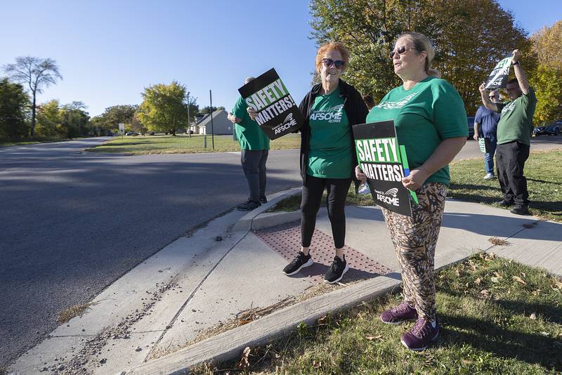 Deb Dickinson (left) and Lynette Roach demonstrate outside of Dixon Correctional Center Thursday, Oct. 17, 2024. Though the two are retired, they recognize the need for safer working conditions are needed.