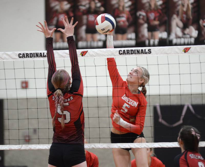 Oregon's Skylar Bishop (5) spikes as Stillman Valley's Aleigha Hodge (5) goes up to block during a Big Northern Conference contest on Thursday, Oct. 17, 2024 at Stillman Valley. The Hawks won the contest in three sets.