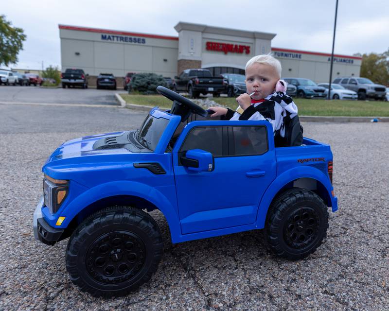 Hudson Hoge drives toy car down road at the trunk or treat event on Saturday, October 25, 2025 at Illinois Valley Auto Group in Peru.