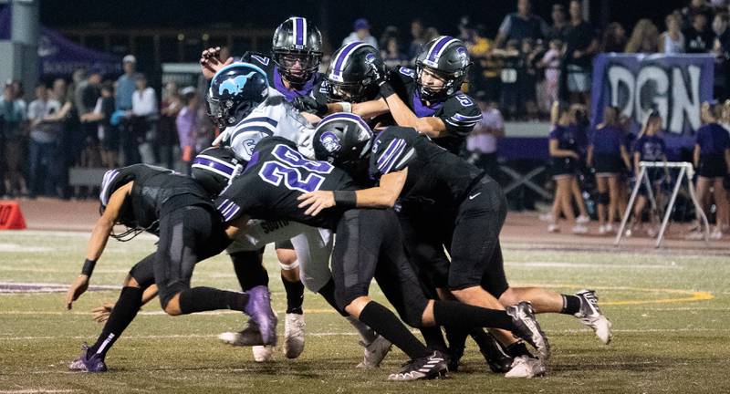Six Downers Grove North defenders gang tackle Downers Grove South's Deon Davis (6) for a loss during a football game at Downers Grove North High School on Friday, Sep 9, 2022.