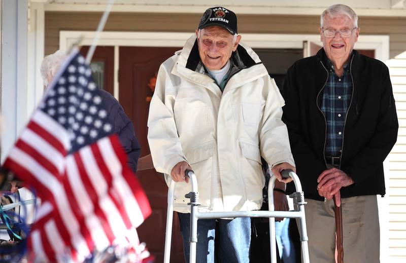 US Navy veteran Richard Korleski, (left) 93, and Ken Cooper, 96, a US Army veteran, smile as they watch members of the Kunkel family pass by in a small parade on Veterans Day,  Friday, Nov. 11, 2022, at the Grand Victorian assisted living facility in Sycamore. Sycamore resident Joann Kunkel read a story in the current Midweek that contained a quote from one of the veterans at the facility that lamented the lack of a parade. So she and her grandkids decided to have one for them.