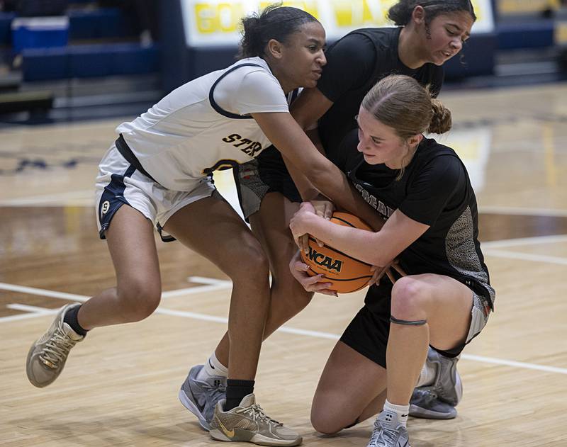 Sterling’s Alivia Gibson and Galesburg’s Ella Herchenroder fight for a ball Thursday, Dec. 4, 2025.