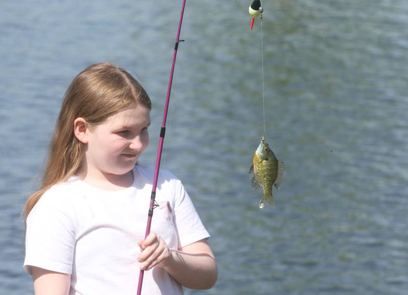 Jadyn O'Brian of Ottawa, catches a bluegill on her pole during the 25th annual Kids Fishing Expo on Saturday, May 10, 2025 at Baker Lake in Peru.