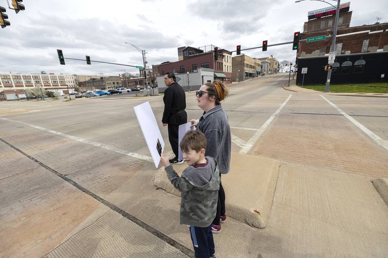 Walker Wertz, 7, and mom Chelsea wait to cross Galena Avenue during a Hands Off rally in Dixon Saturday, April 19, 2025. This is Walker’s third protest.