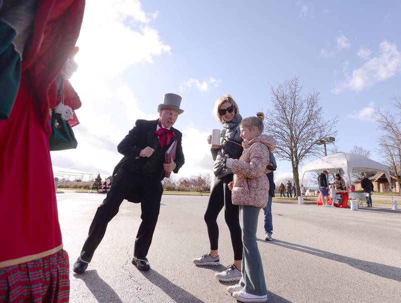 Christmas Carolers including Anthony Cesaretti sing to families including Jenny Johnston and her daughter Sloane of Glen Ellyn while attending the Park District's Polar Market held at Maryknoll Park Saturday, Dec. 9, 2023.