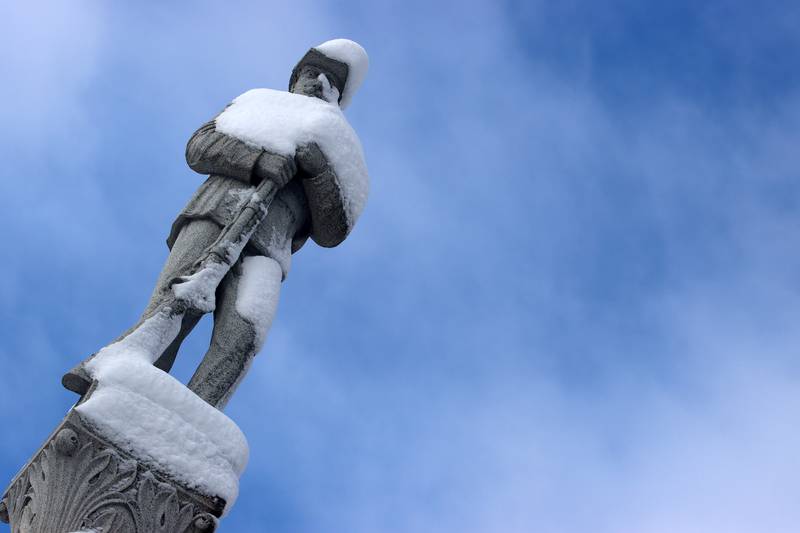 A statue on the Woodstock Square is covered Saturday in the wake of overnight snow. Bitter cold is expected to worsen into Sunday, the National Weather Service warned.