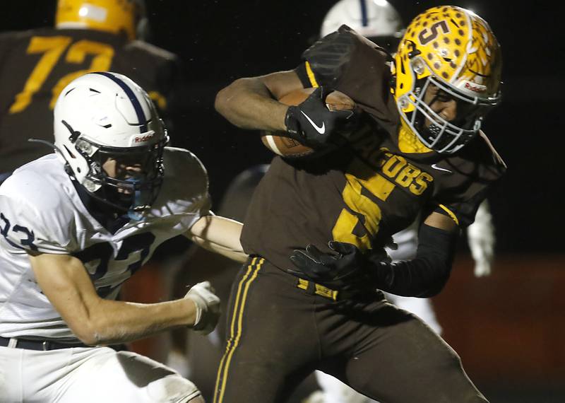 Jacobs' Michael Cannady breaks the tackle attempt of Cary-Grove's Lance Moore during a Fox Valley Conference football game on Friday, Oct. 24, 2025, at Jacobs High School in Algonquin.