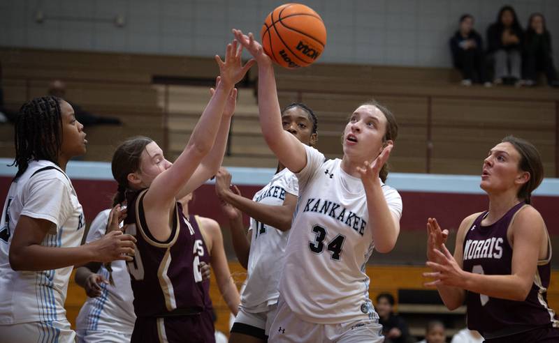 Morris's Maddi Simpson, center left, and Kankakee's Ava Johnson, center right, look to grab a rebound in a game on Tuesday, January 27, 2026.