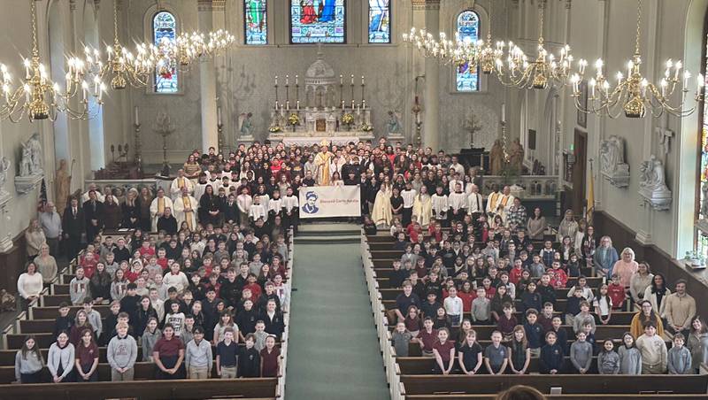 Students from Trinity Catholic Academy in La Salle, Peru Catholic School and Holy Family School in Oglesby pose for a photo with The Most Reverend Bishop Louis Tylka, Bishop of Peoria after the All Schools Mass on Thursday, Feb. 20, 2025 in La Salle. The bishop gave Mass while announcing a new name for the three schools calling it Carlo Acutis. Last year, the Catholic Diocese of Peoria announced the consolidation of the three schools. Carlo Acutis Canonization will take place on Sunday, April 27, 2025 during the Jubilee of Teenagers in Rome. Acutis is the first millennial saint, representing those born between the early 1980's and the late 1990's. He is celebrated for cataloging miracles and online and managing websites for Catholic organizations.