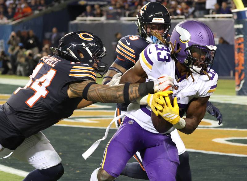 Minnesota Vikings running back Aaron Jones Sr. gets into the endzone for a touchdown as Chicago Bears linebacker Noah Sewell tries to punch the ball away during their game Monday, Sept. 8, 2025, at Soldier Field in Chicago.