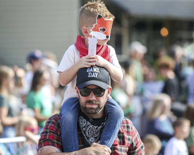 A participant walks with his son on his shoulders in the Plainfield Homecoming parade Saturday, Sept 20, 2025.